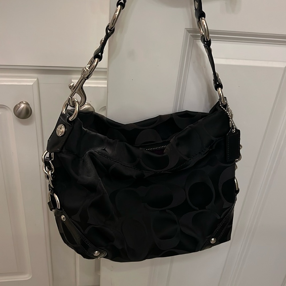 2010 Coach signature shoulder bag. Black on black initial with silver hardware.